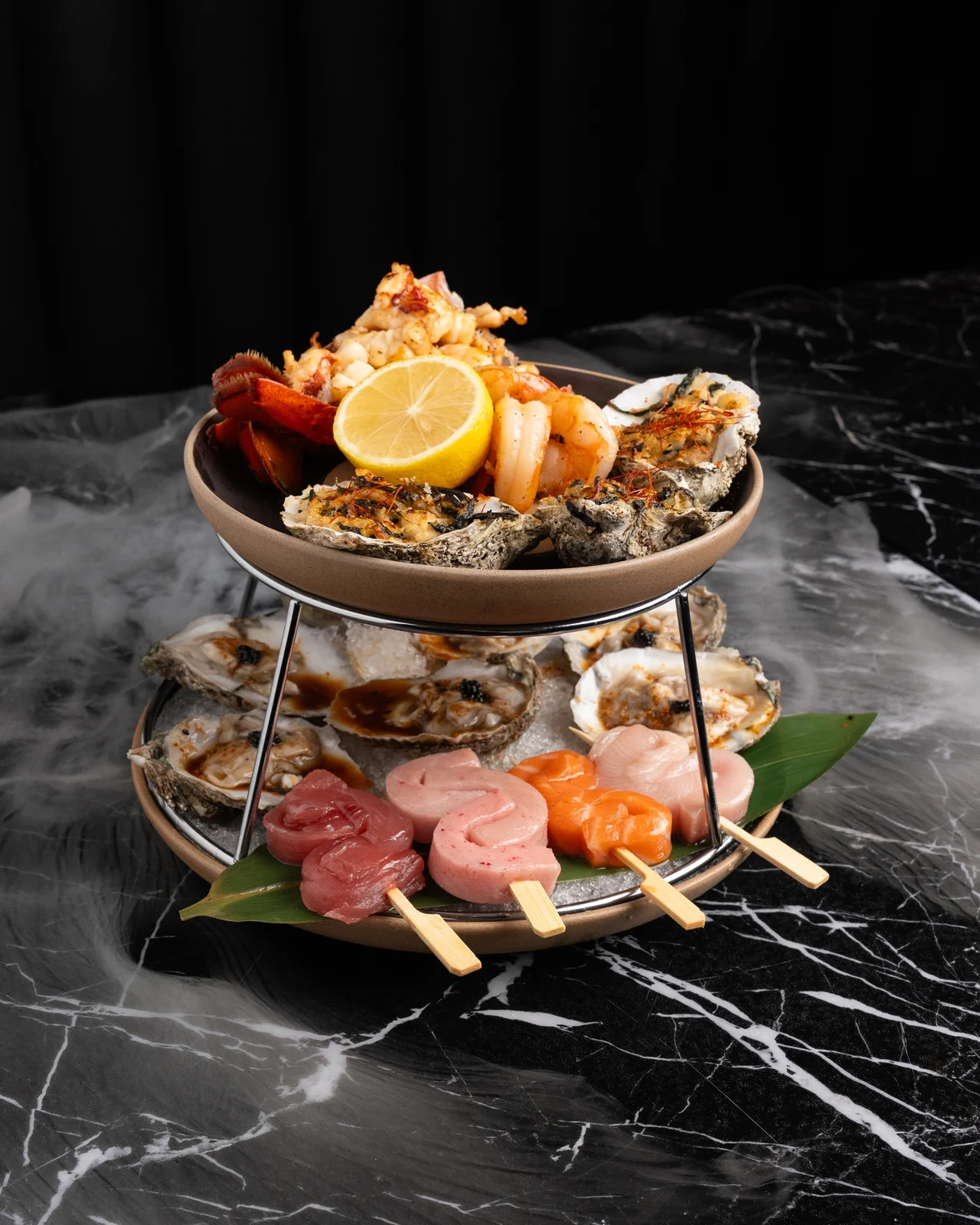 Churasuko seafood tower with sashimi, oysters, and cooked seafood